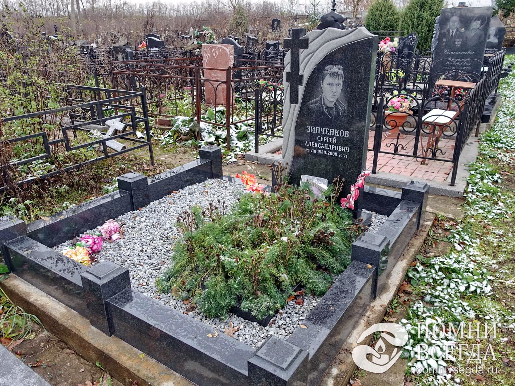 Строгий мемориальный комплекс с зеленеющим цветником